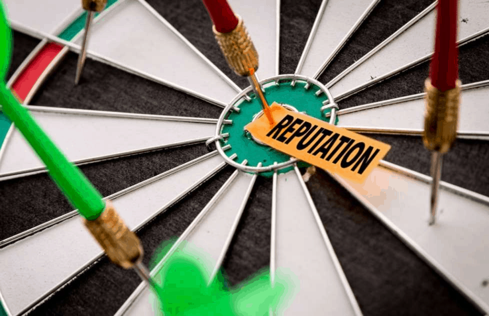 A dartboard with a tag saying 'reputation' pinned to the bullseye with a dart