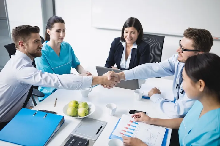 healthcare professionals shaking hands in meeting